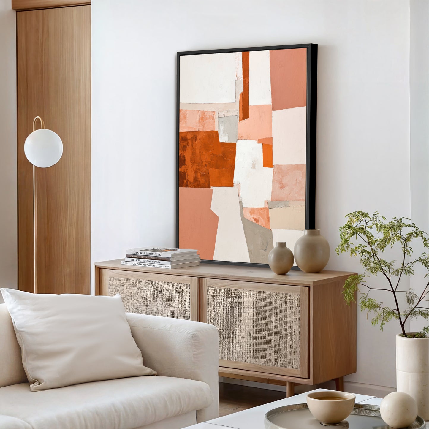 a modern living room with a large abstract painting on the wall, a white sofa, a wooden cabinet, and a potted plant.