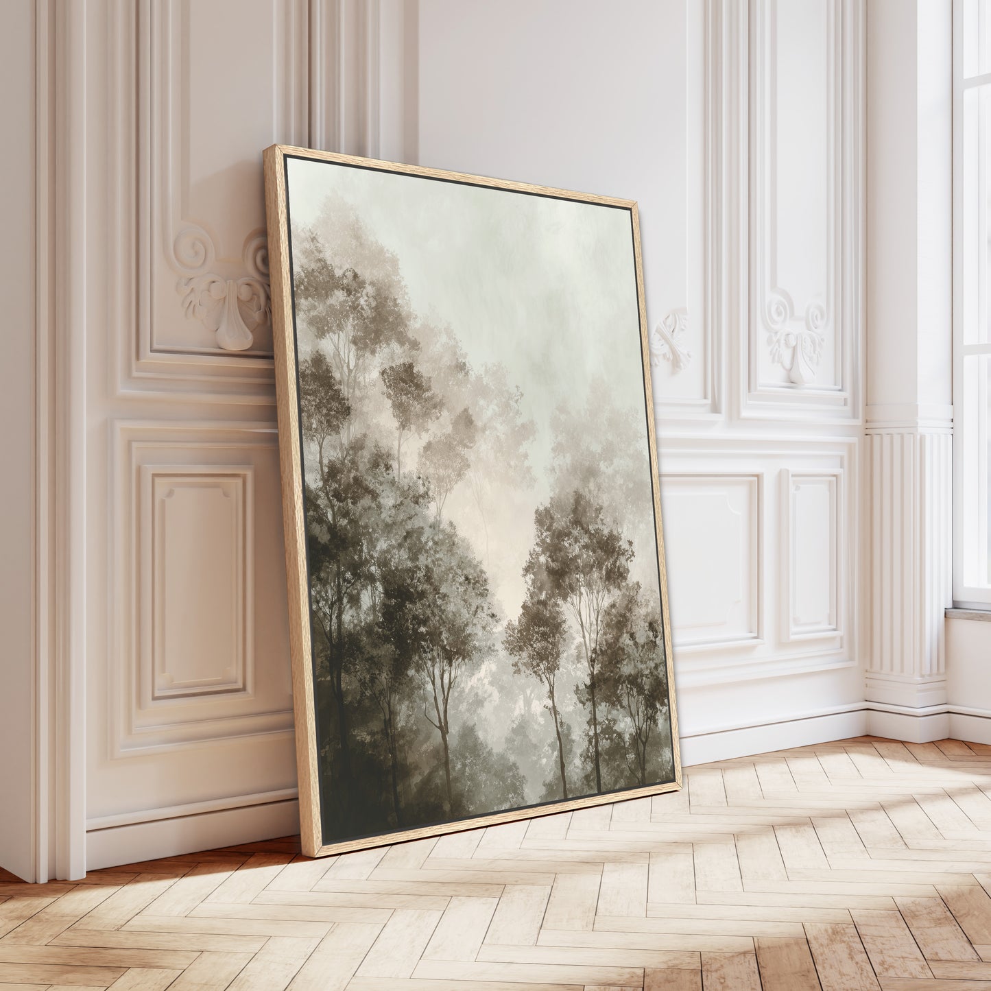 a large framed painting of trees on a white wall, leaning against it in a room with a wooden floor.