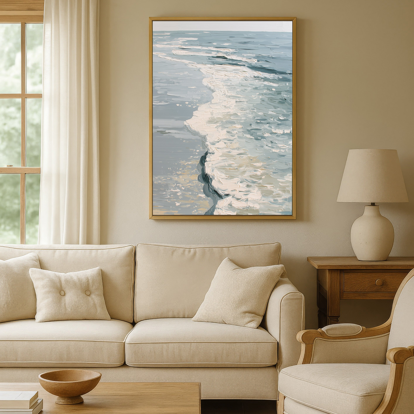 a cozy living room with a large window overlooking the ocean, a framed painting of the ocean waves hanging on the wall, a beige sofa, a wooden coffee table, and a matching beige armchair.