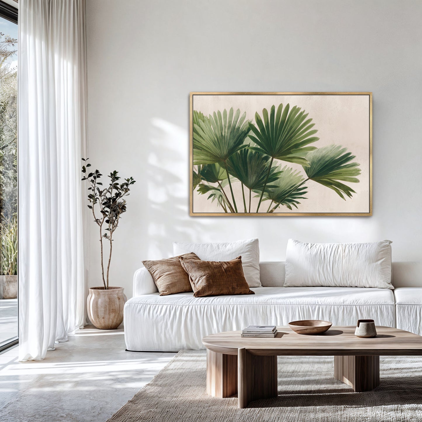 a modern living room with a white sofa, a wooden coffee table, and a large framed print of palm leaves on the wall.