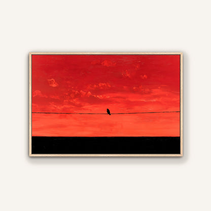 A lone bird perched on a wire against a vibrant red sky.