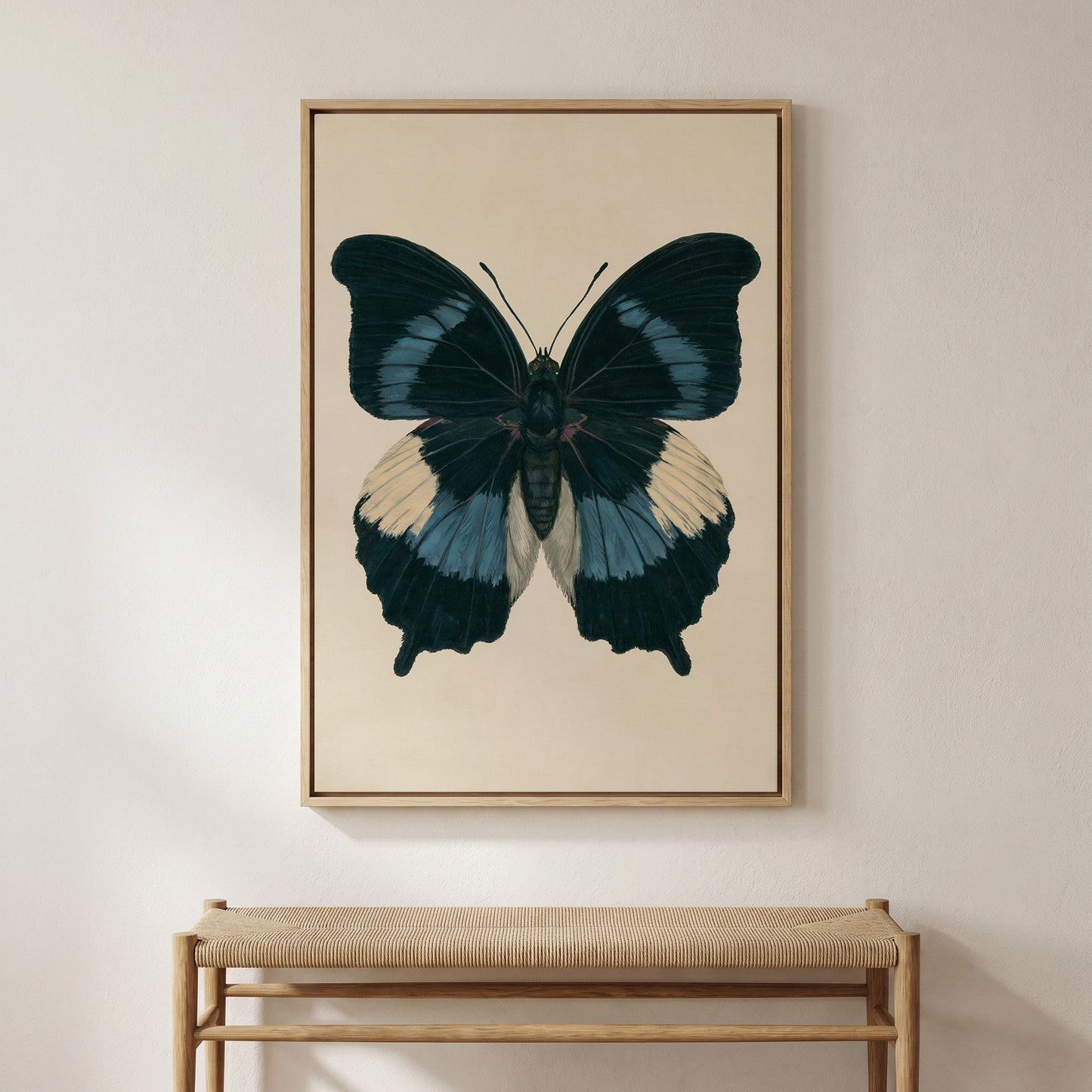 a large framed painting of a colorful butterfly hanging on a wall above a wooden bench.