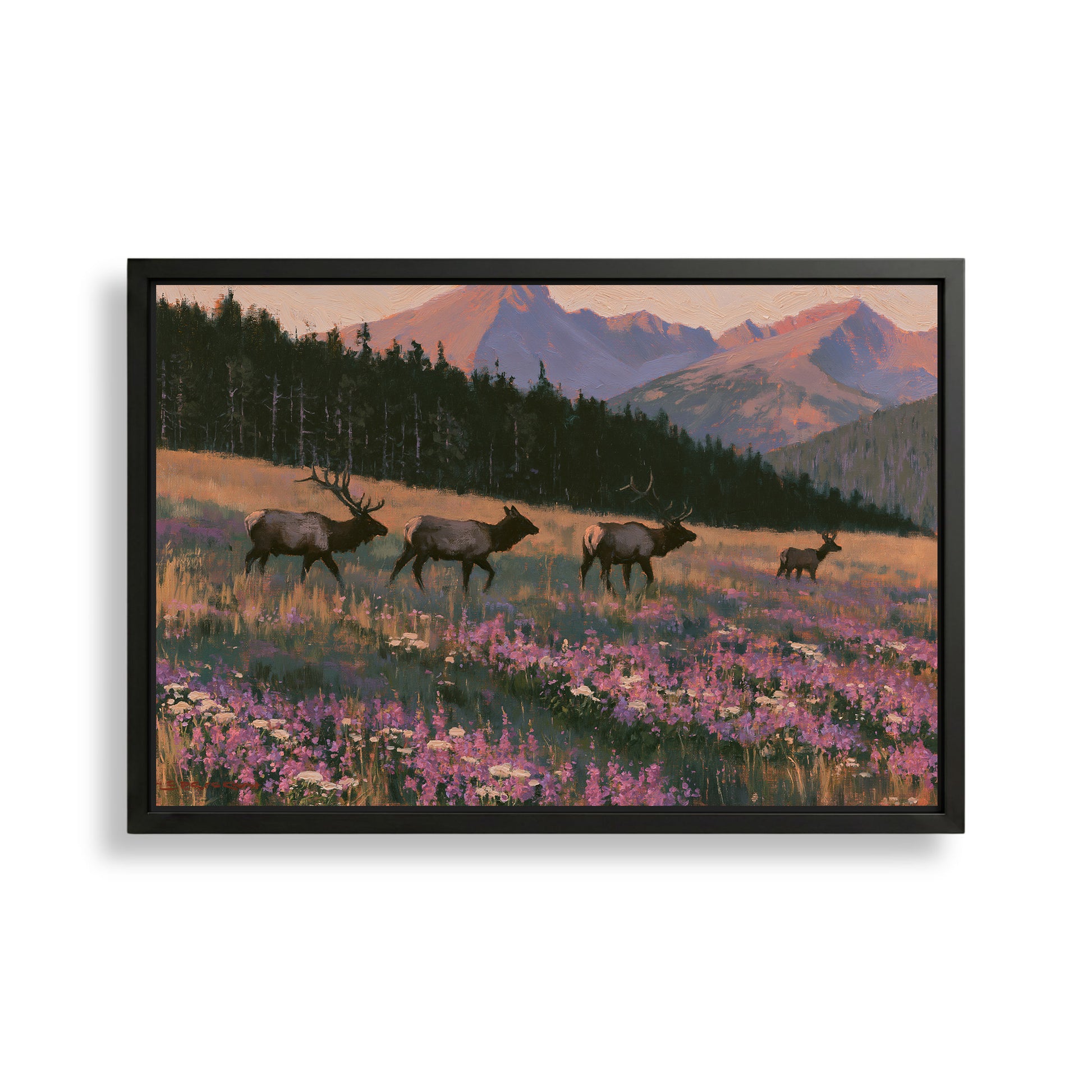A framed painting depicting a group of elk walking through a field of wildflowers, with mountains in the background.