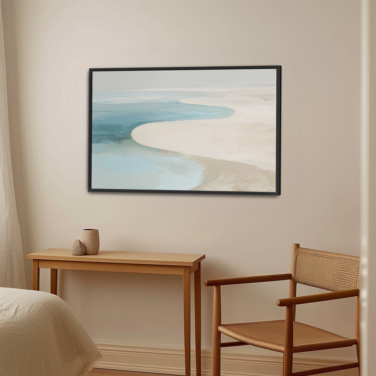 Tideway Canvas Wall Art depicting serene sea and sand in soft blue and beige tones with black frame in minimalist room setting