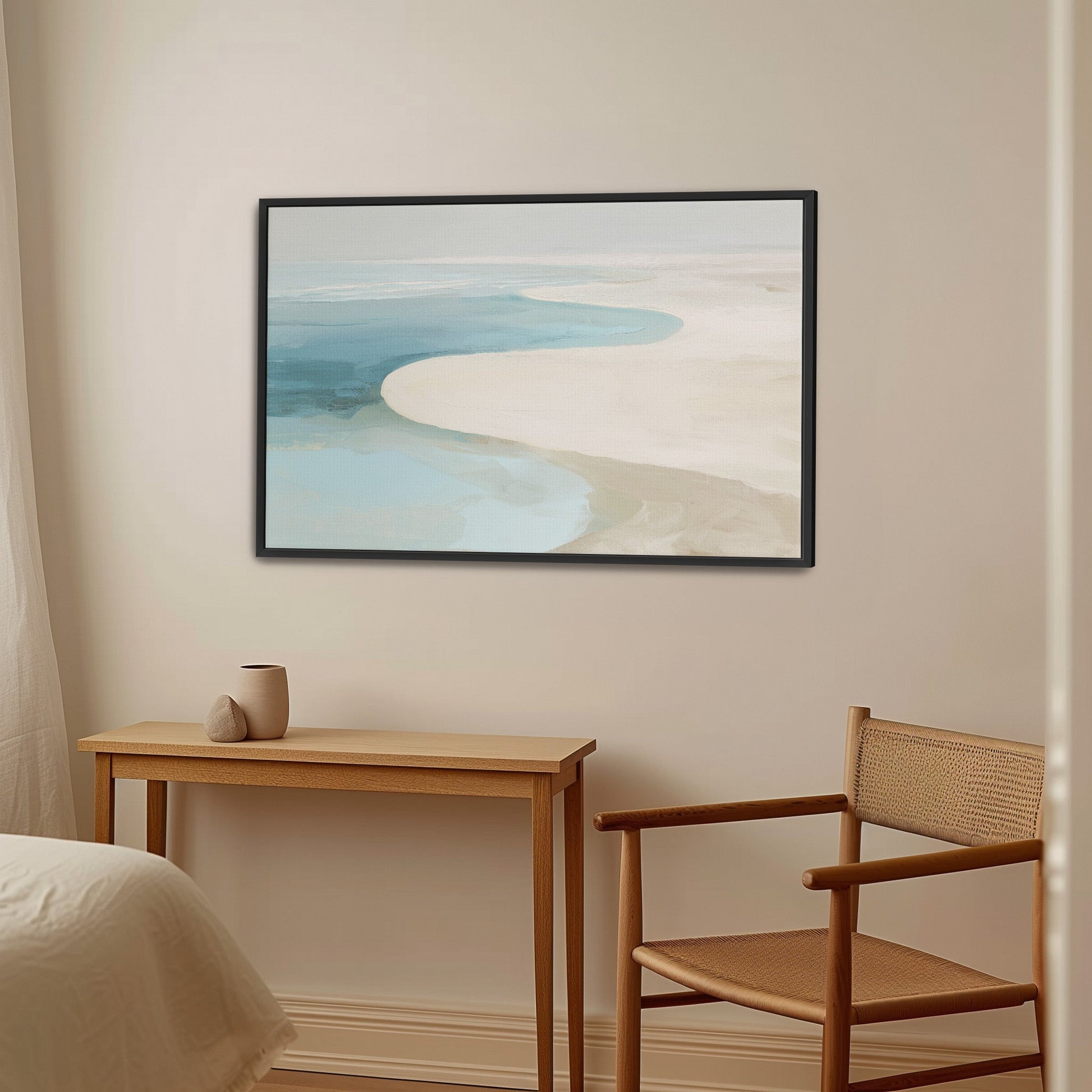 Tideway Canvas Wall Art depicting serene sea and sand in soft blue and beige tones with black frame in minimalist room setting