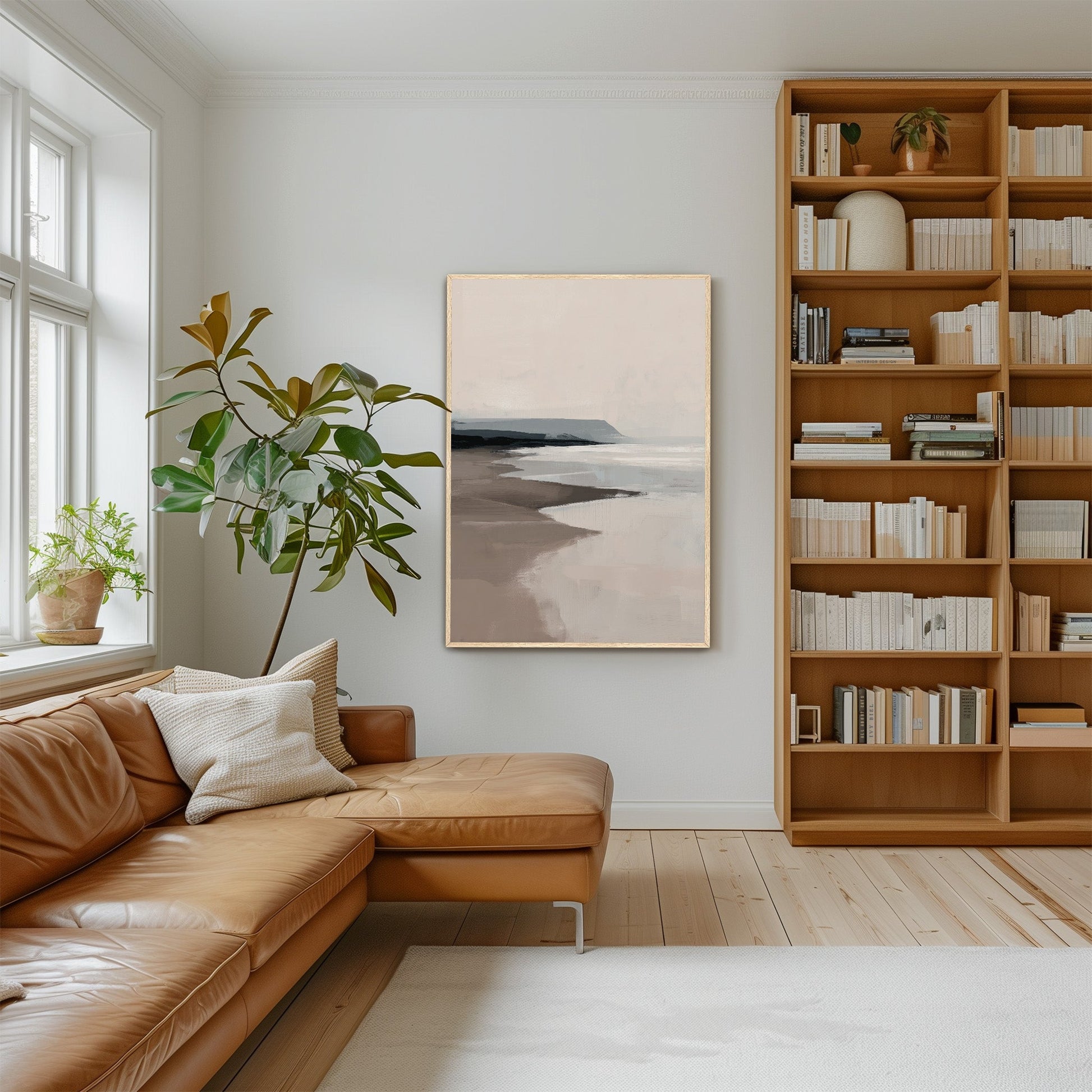 Mel canvas print with soft beige and gray seascape in modern living room with leather sofa and wooden bookshelf