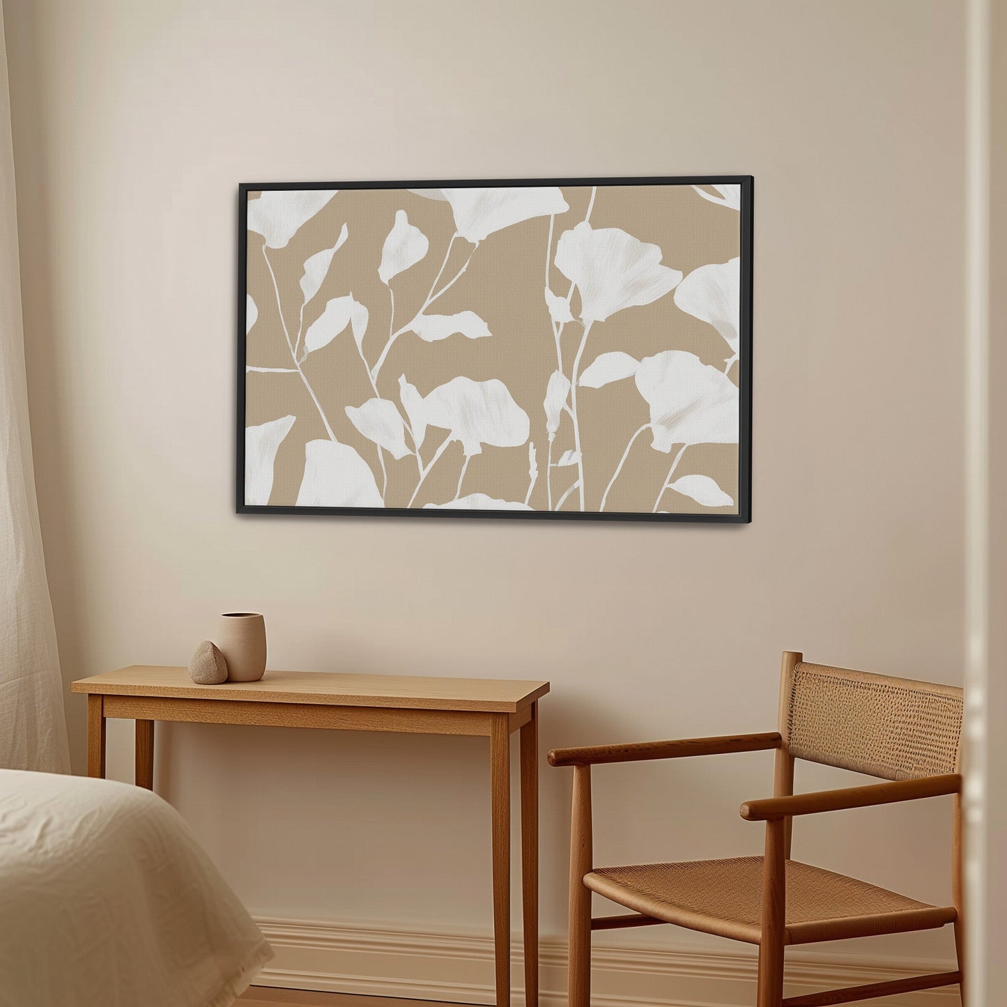 Driftleaf canvas print with white floral silhouettes on beige, framed in black, hanging in minimalist room