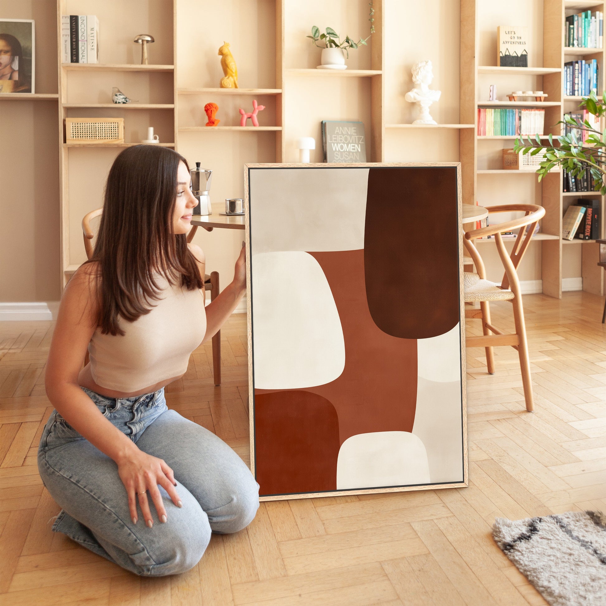 Woman holding Formation Canvas Print with abstract sienna, ivory, and espresso shapes in modern living room