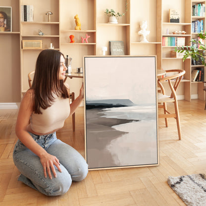 Woman sitting next to Mel Canvas Print with beige and gray abstract seascape in modern living room
