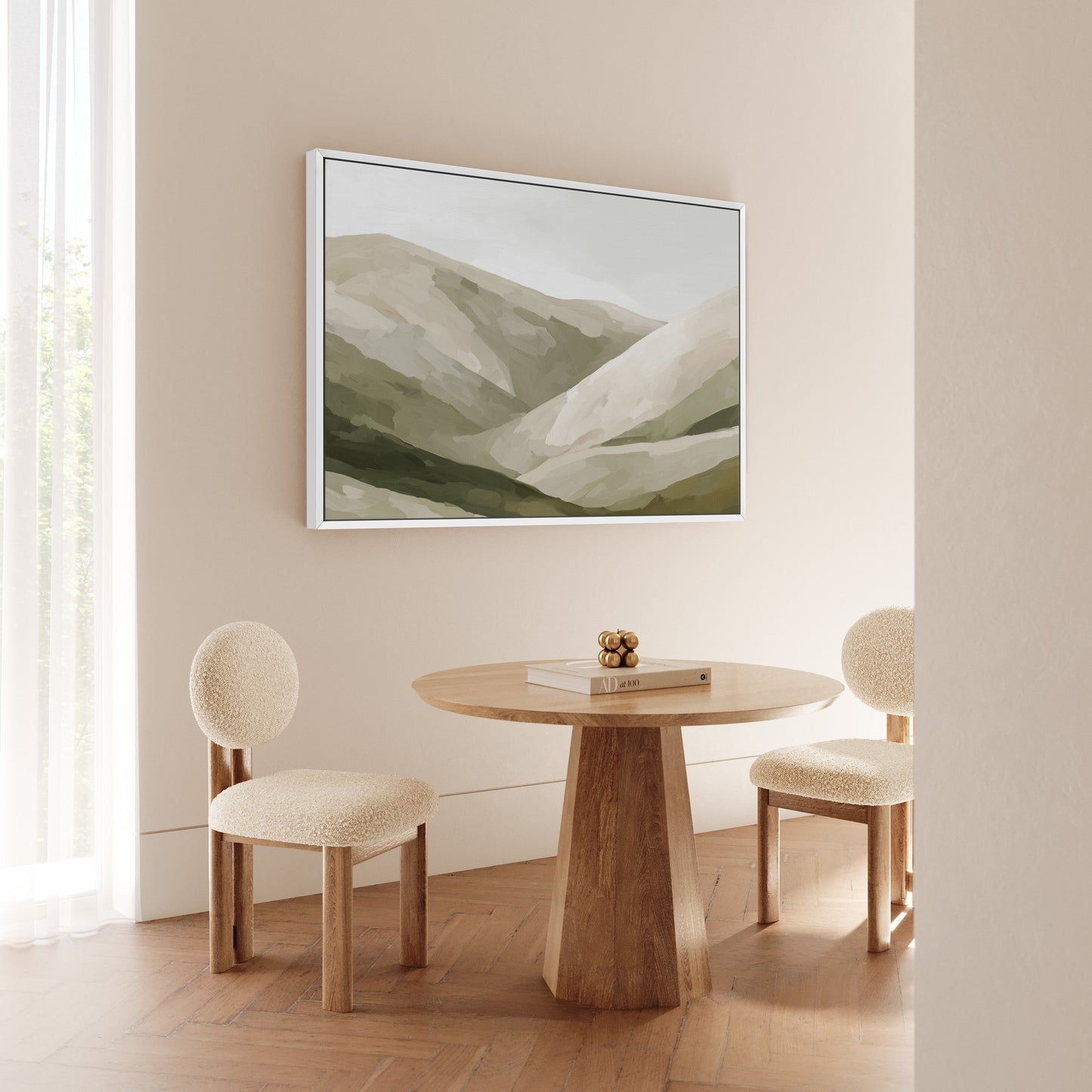 Olive Hills canvas print with layered olive and taupe hills in a neutral framed setting above a wooden table and cream chairs.