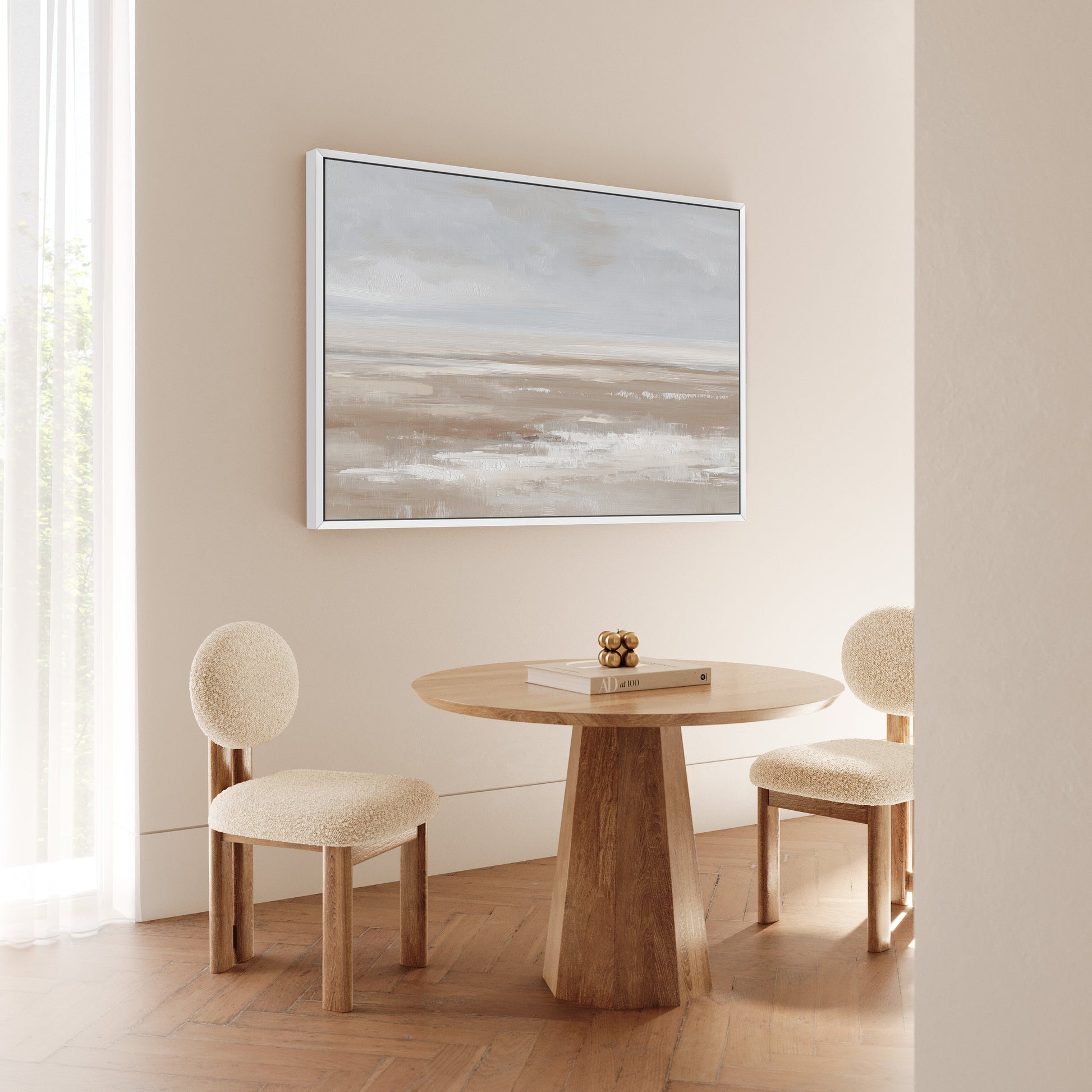 Barren Canvas Print minimalist landscape in taupe and cream tones framed in white hanging above a wooden round table with two beige chairs in a modern neutral dining room