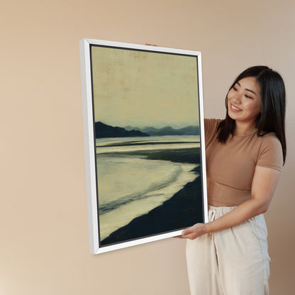 Woman holding Echoes Canvas Print framed in white with calm shoreline in blues and ochre tones