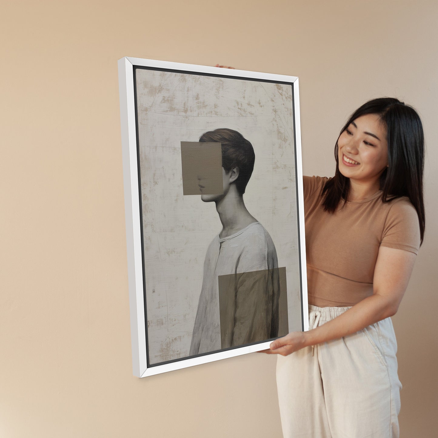 Woman holding a framed Masked Canvas Print featuring abstract portrait with muted tones and geometric shapes