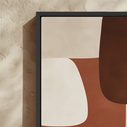 Abstract Formation Canvas Print with sienna, ivory, and espresso shapes in a black frame on textured wall
