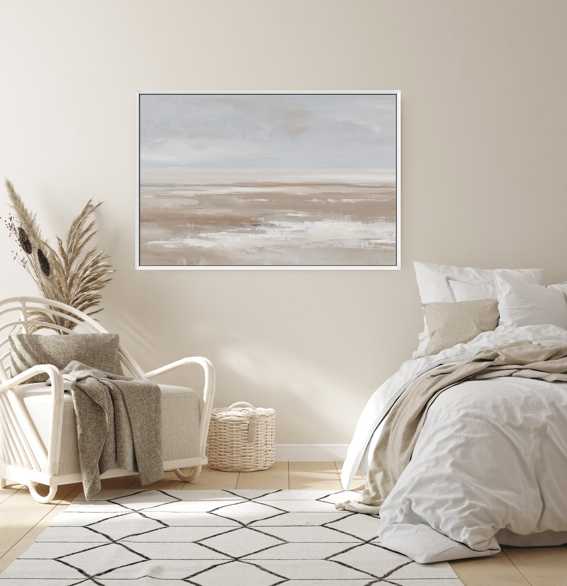 Minimalist barren canvas print in neutral tones above cozy bedroom chair and bed