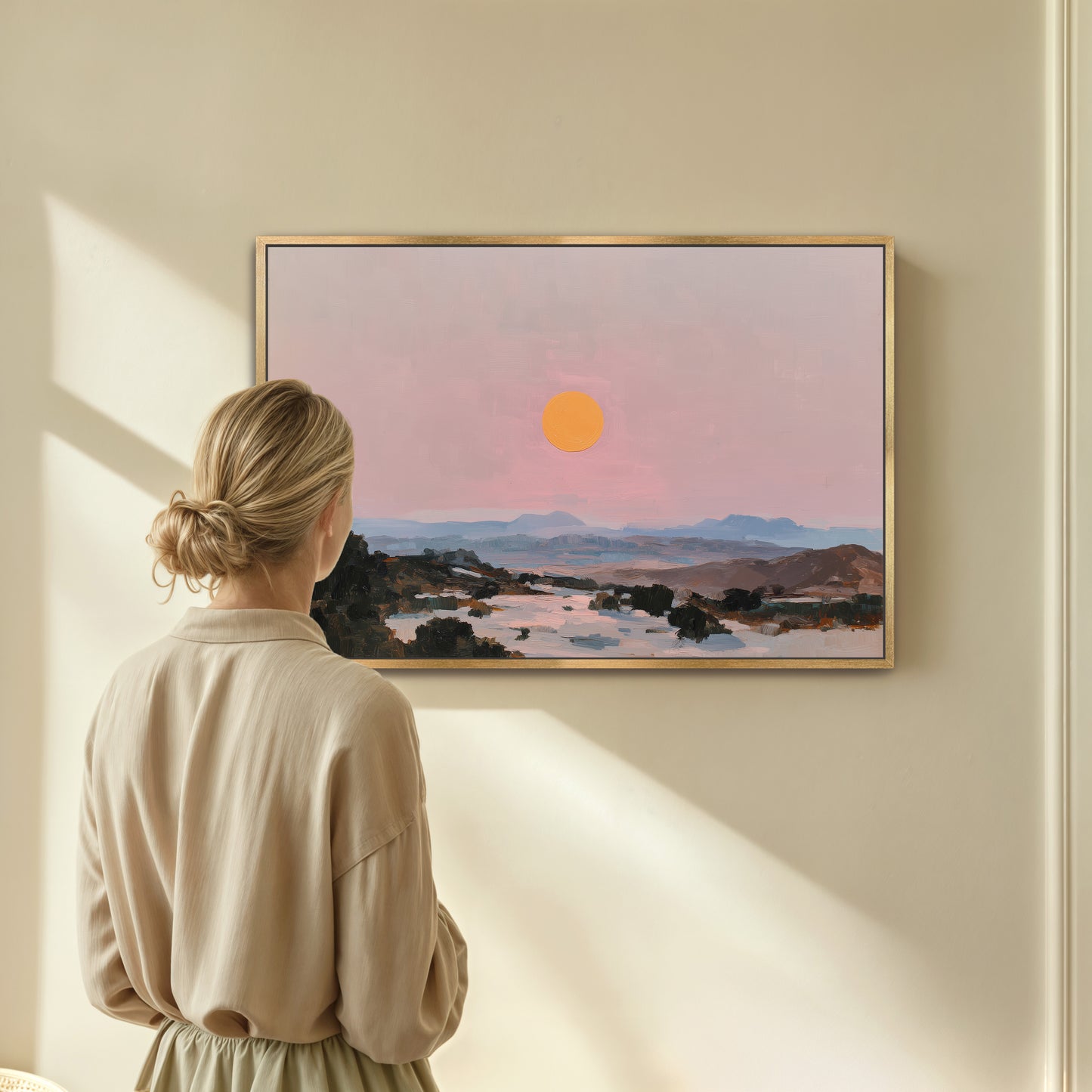 A woman stands in front of a painting, gazing at the landscape depicted in the artwork.