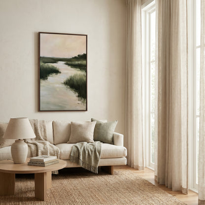 a serene living room with a large window, a white sofa, a wooden coffee table, and a framed landscape painting hanging on the wall.