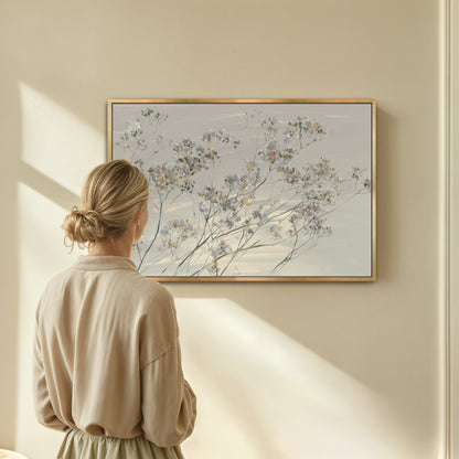 woman observing 'Breeze' Wall Art canvas featuring delicate wildflowers in soft muted tones