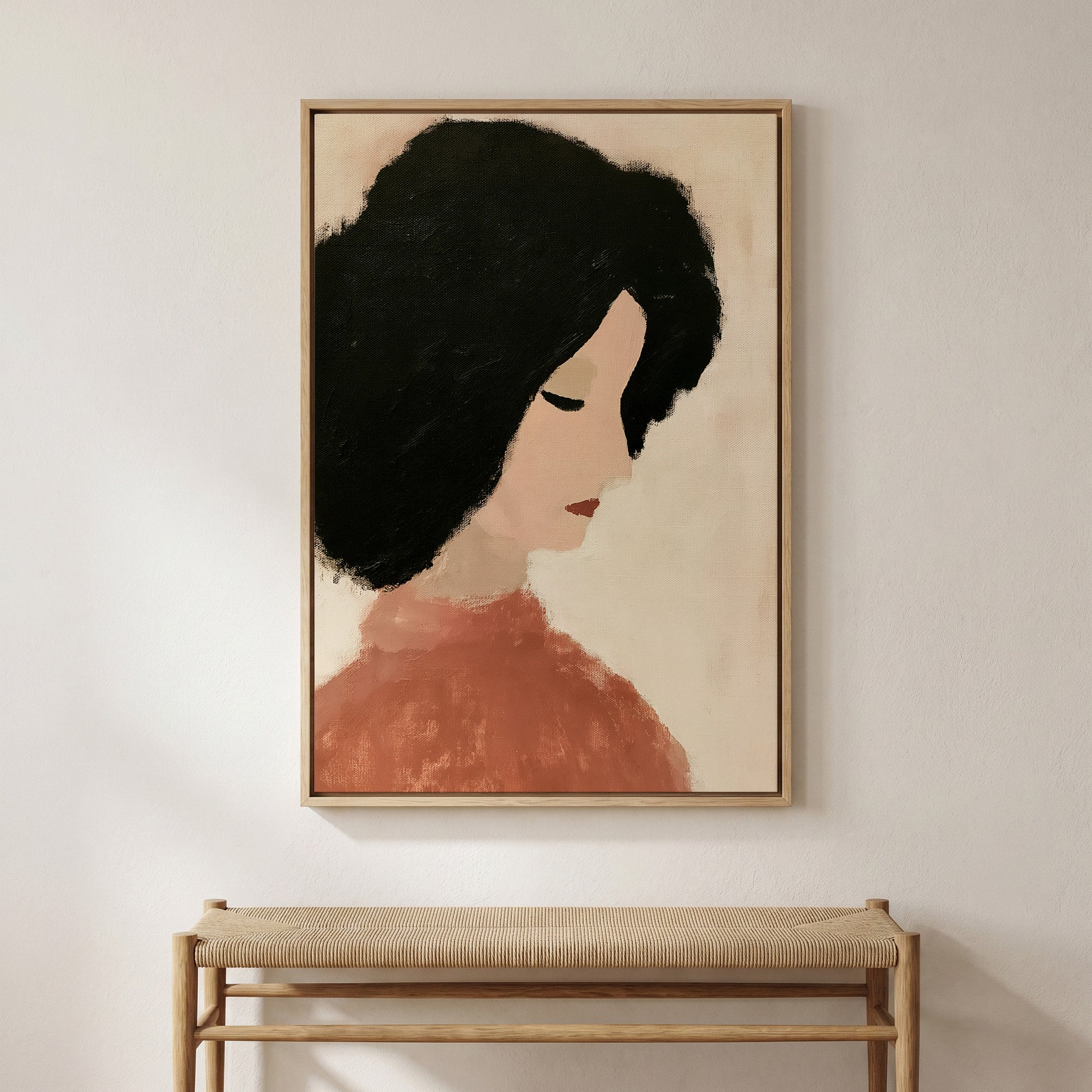 a framed painting of a woman's face with a neutral color palette, hanging on a wall above a wooden bench.