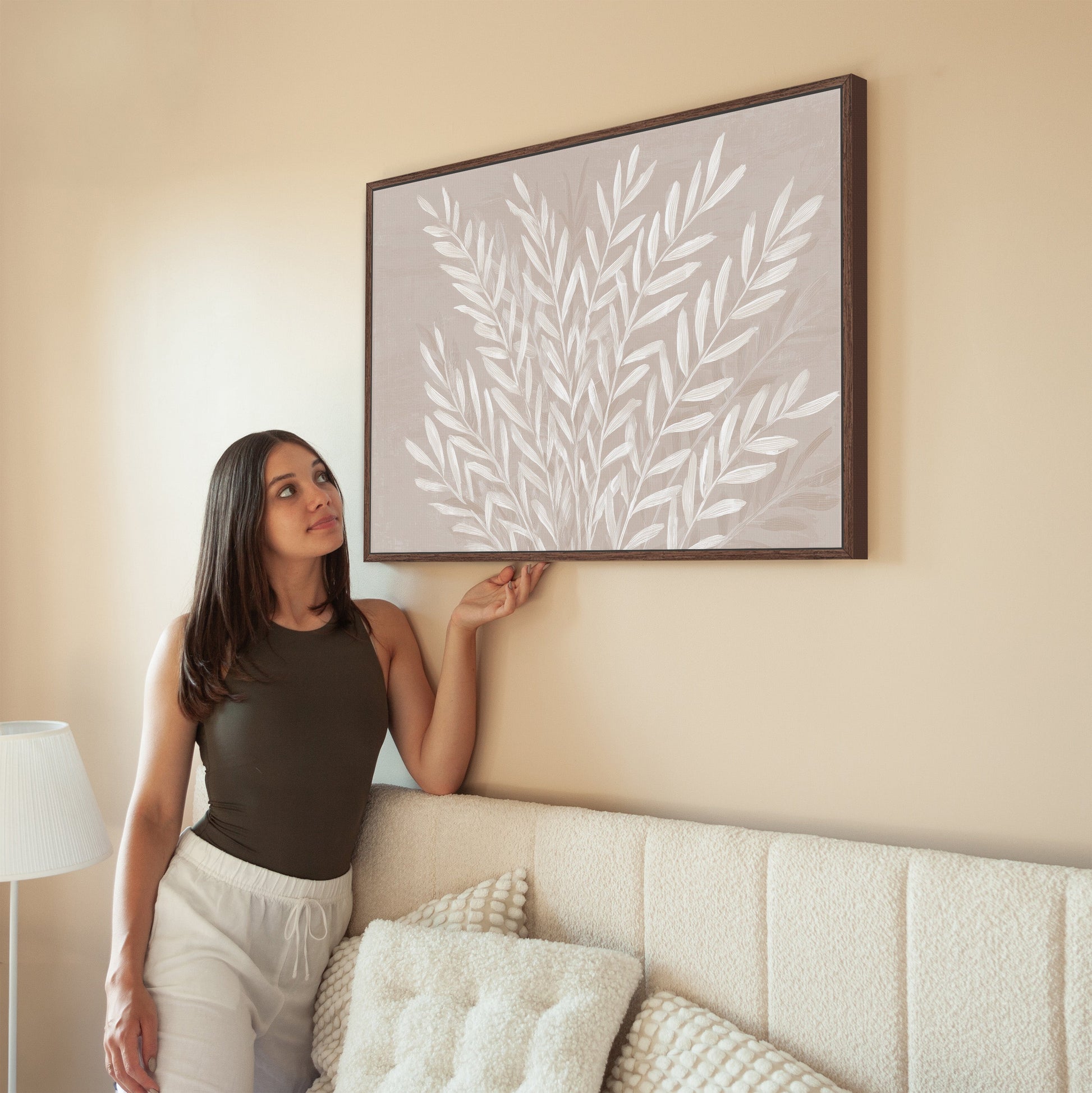 Whisper canvas print featuring ivory leaves on taupe background in modern living room setting
