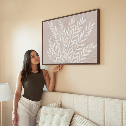 Whisper canvas print featuring ivory leaves on taupe background in modern living room setting