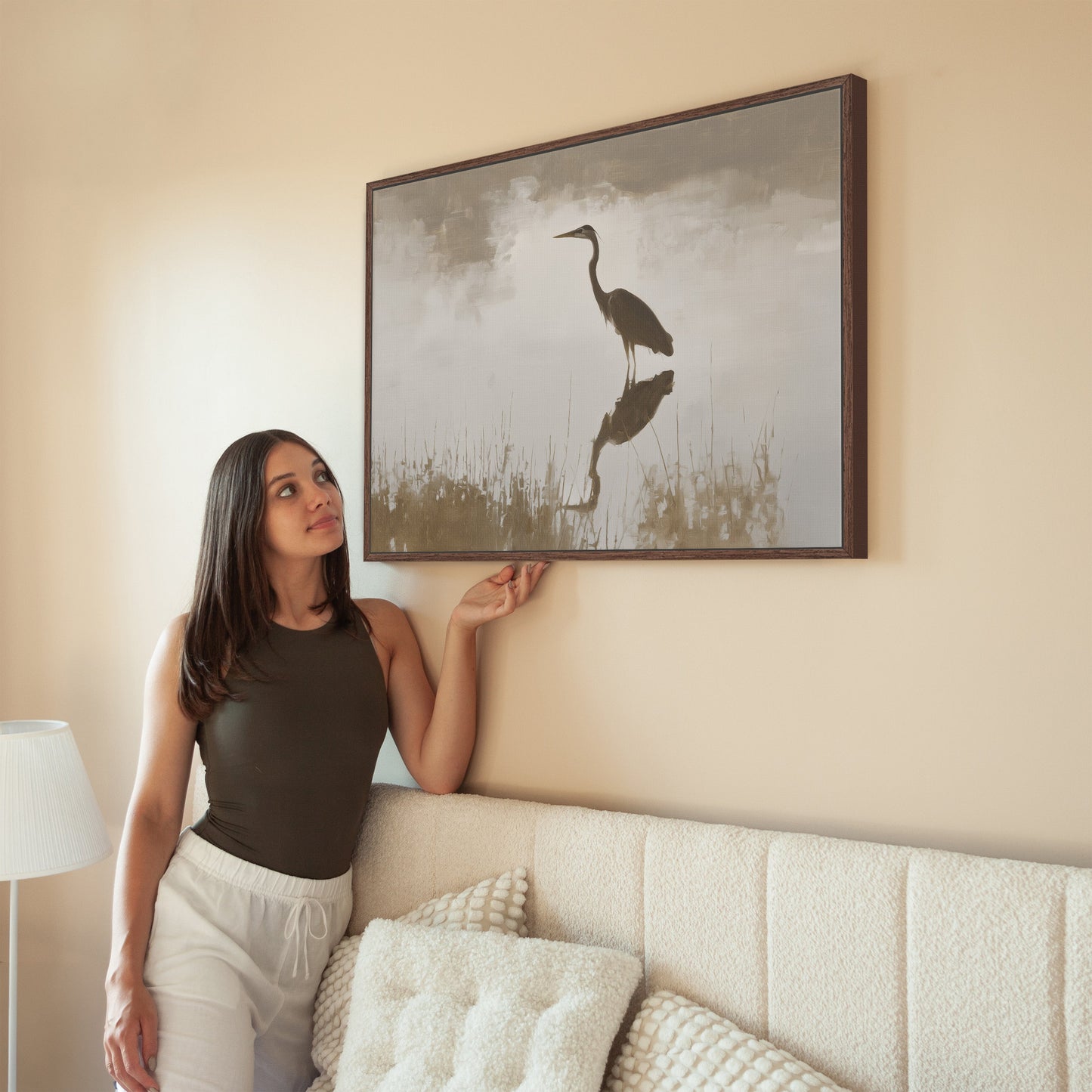 Wade canvas print featuring a heron in serene water with muted earth tones, framed in solid wood, hanging in a minimalist living room