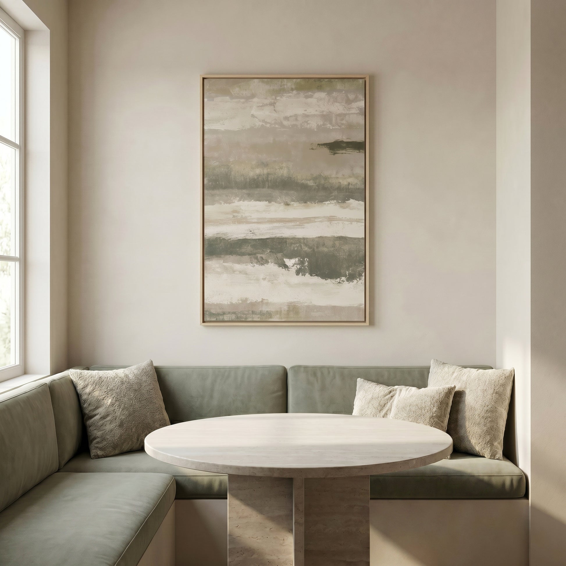 a cozy corner of a room with a round table and two green couches, accompanied by a large abstract painting hanging on the wall above the table.