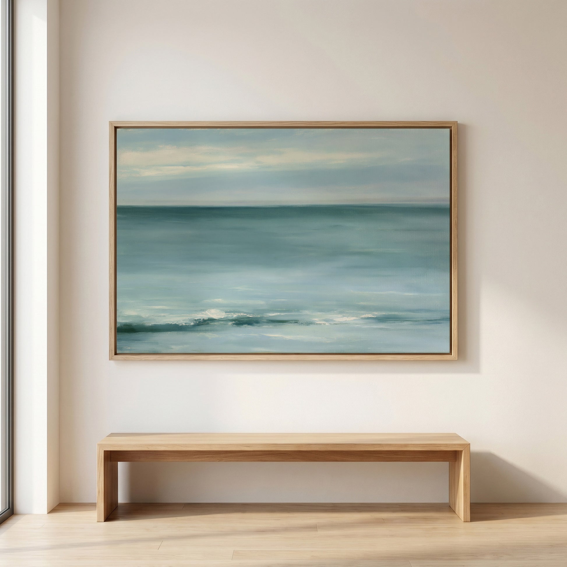 a large painting of a serene ocean scene hanging on a wall above a wooden bench.