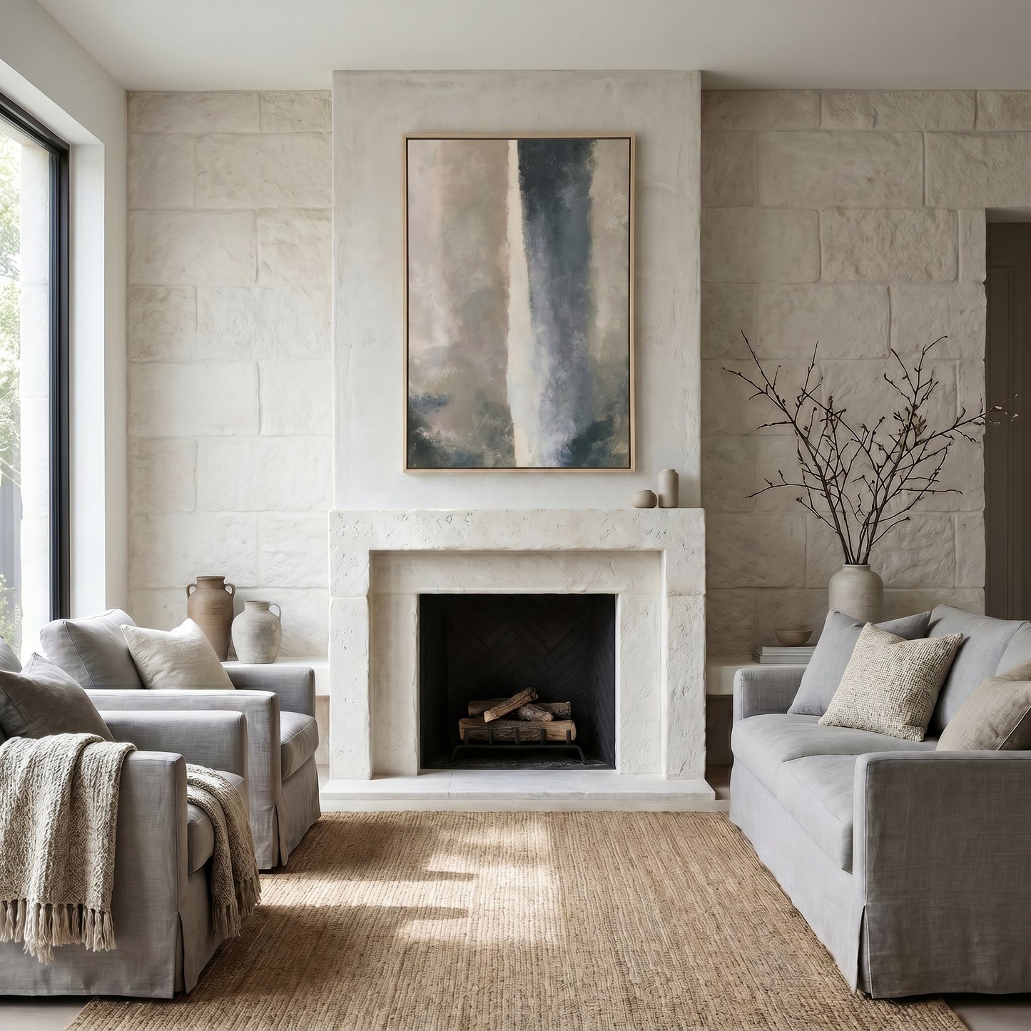 a cozy living room with a fireplace, two gray sofas, and a large abstract painting on the wall.