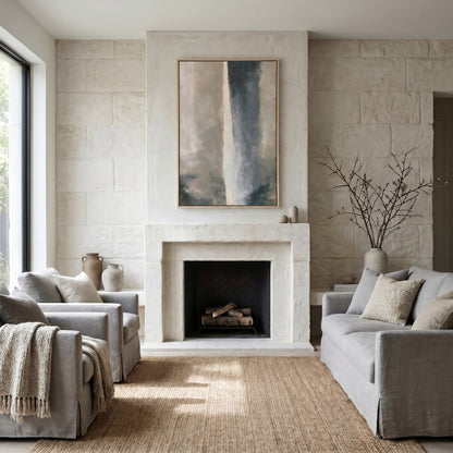 a cozy living room with a fireplace, two gray sofas, and a large abstract painting on the wall.