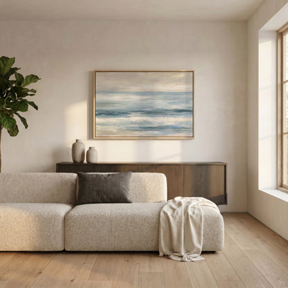 a serene living room with a large window, a white sofa, a wooden cabinet, and a framed painting of a blue sky with clouds hanging on the wall.