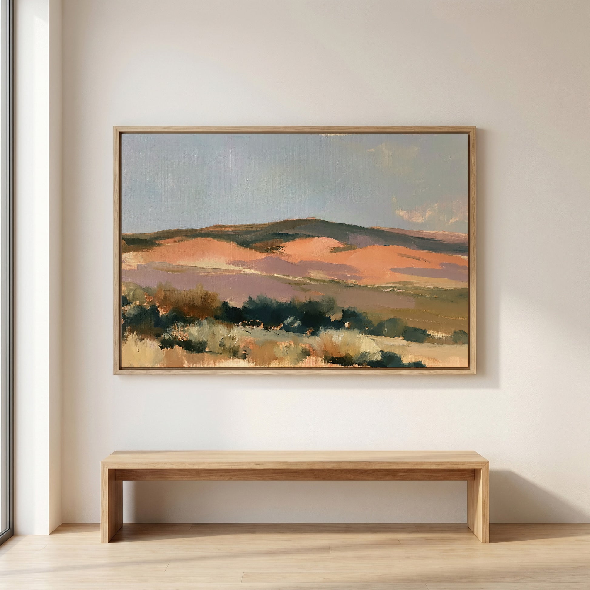 a large landscape painting hanging on a white wall above a wooden bench.