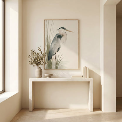 a minimalist interior design with a large framed picture of a heron on the wall, a white console table with a vase of greenery and a bowl, and a window providing natural light.