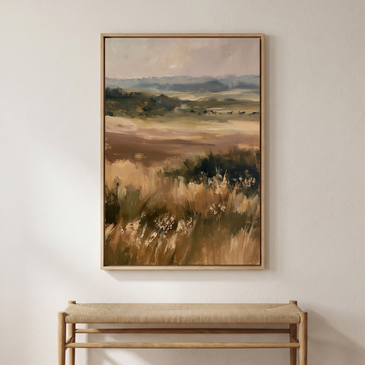 a large landscape painting hanging on a wall above a wooden bench.