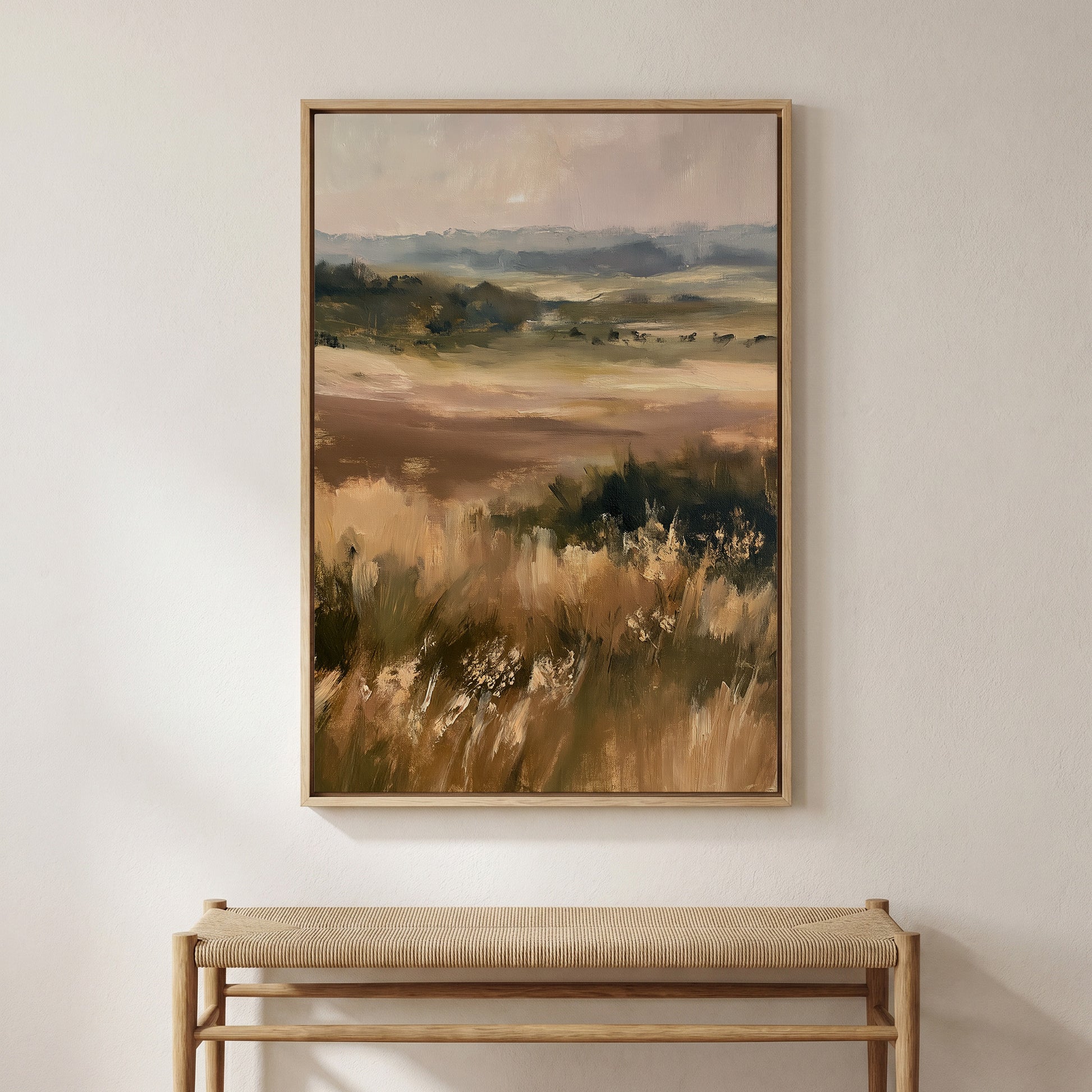 a large landscape painting hanging on a wall above a wooden bench.