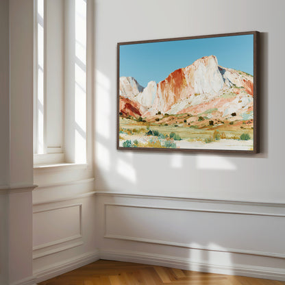a large, framed painting of a mountainous landscape hanging on a white wall.