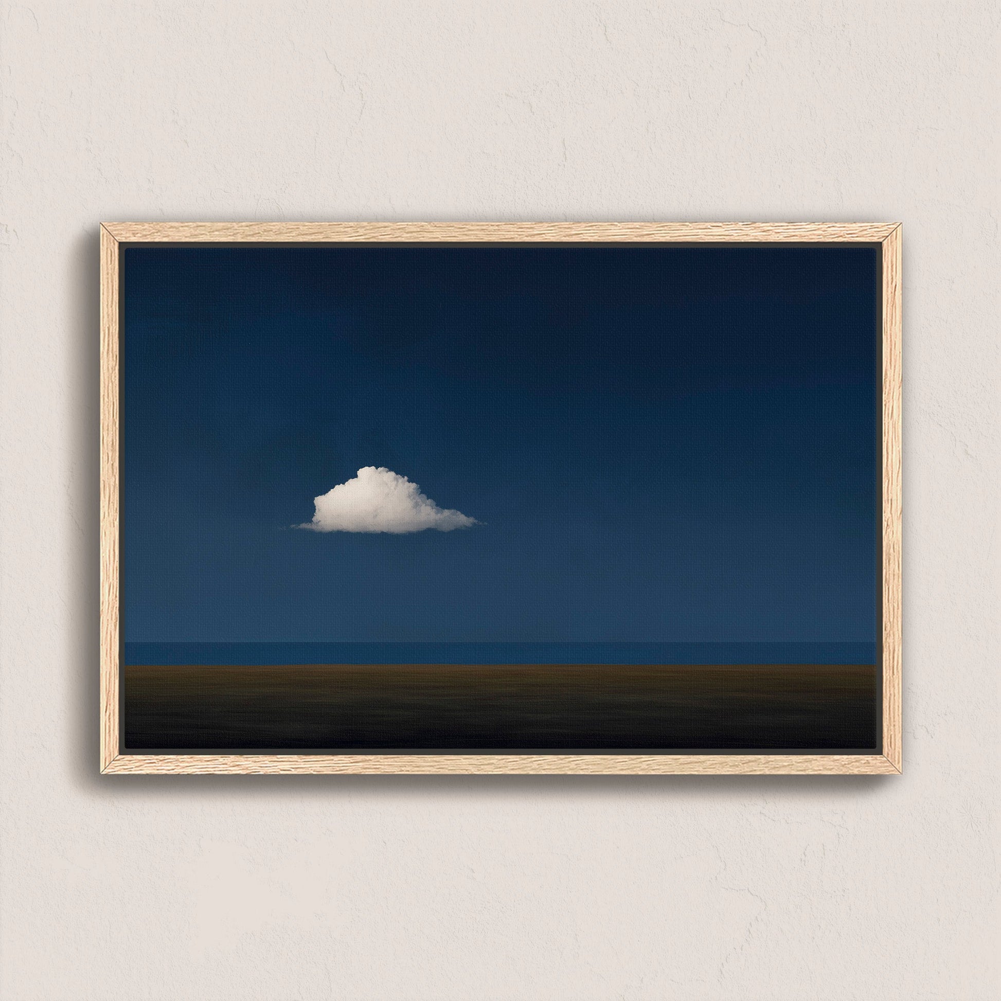 Nimbus Canvas Print featuring a solitary white cloud over a midnight blue horizon in a natural wood frame.