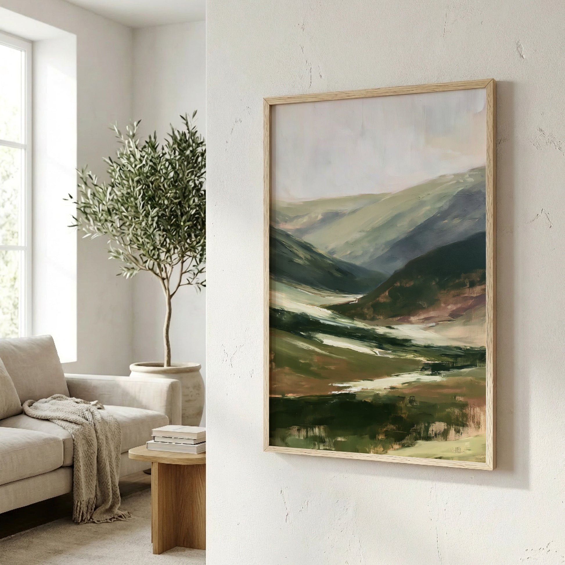 a living room with a large painting of a landscape hanging on the wall, a sofa, a potted plant, and a wooden side table.