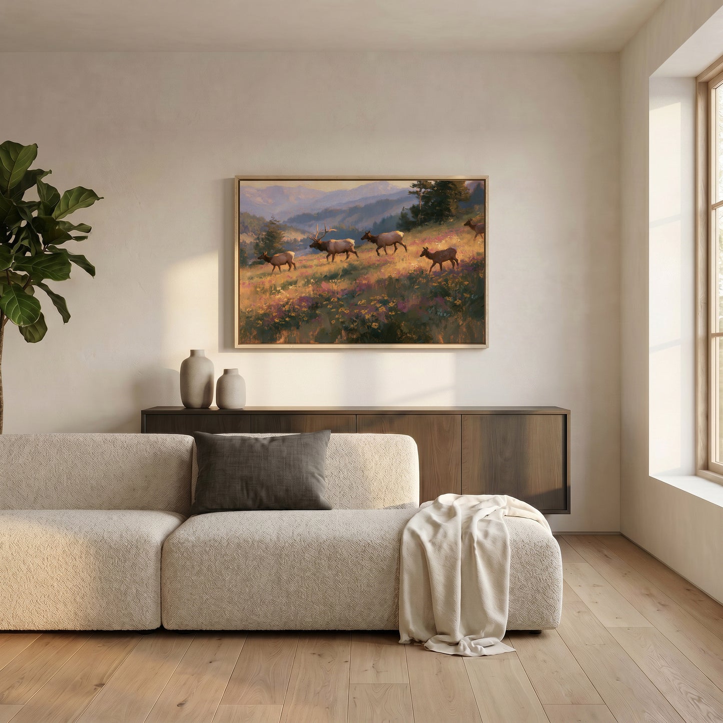a serene living room with a large painting of a group of deer in a field hanging on the wall above a beige sofa.