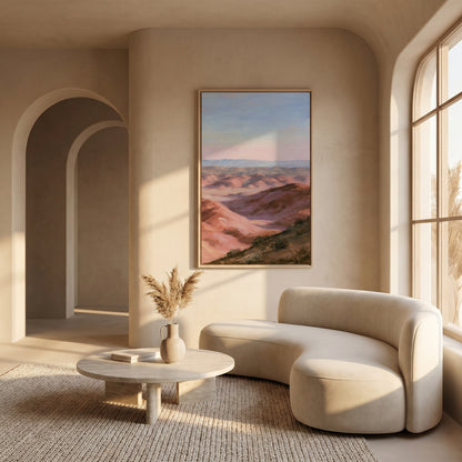 a modern living room with a curved white sofa, a round wooden coffee table, and a large framed landscape painting hanging on the wall.