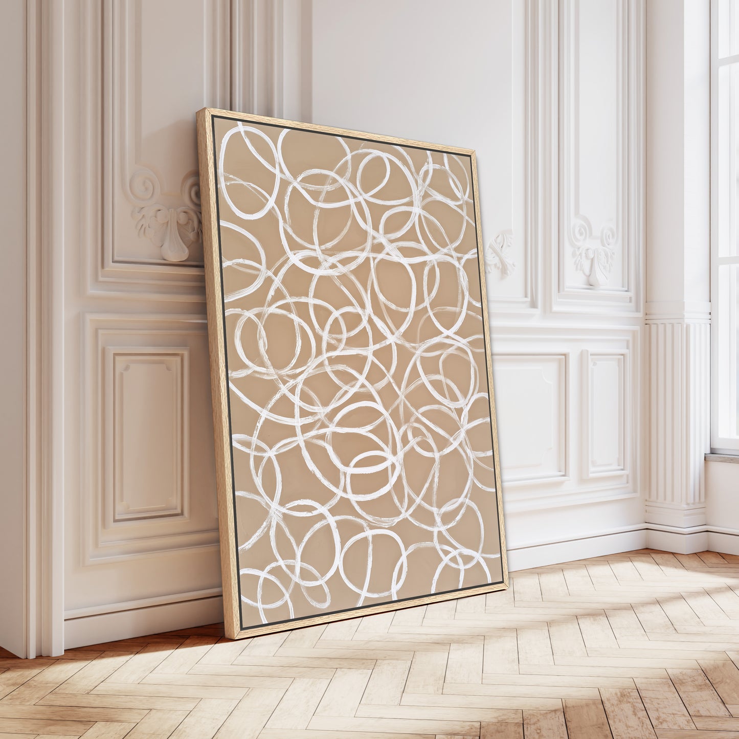 a large, abstract painting with a circular pattern on a white background, displayed on a wooden floor against a white wall.
