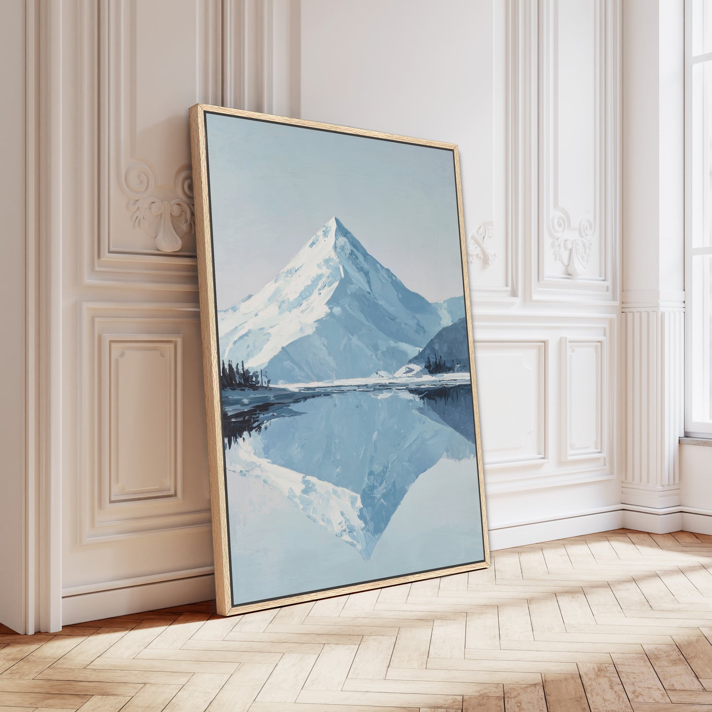 A large framed painting depicting a serene mountain landscape with a calm lake in the foreground, set against a pale blue sky.