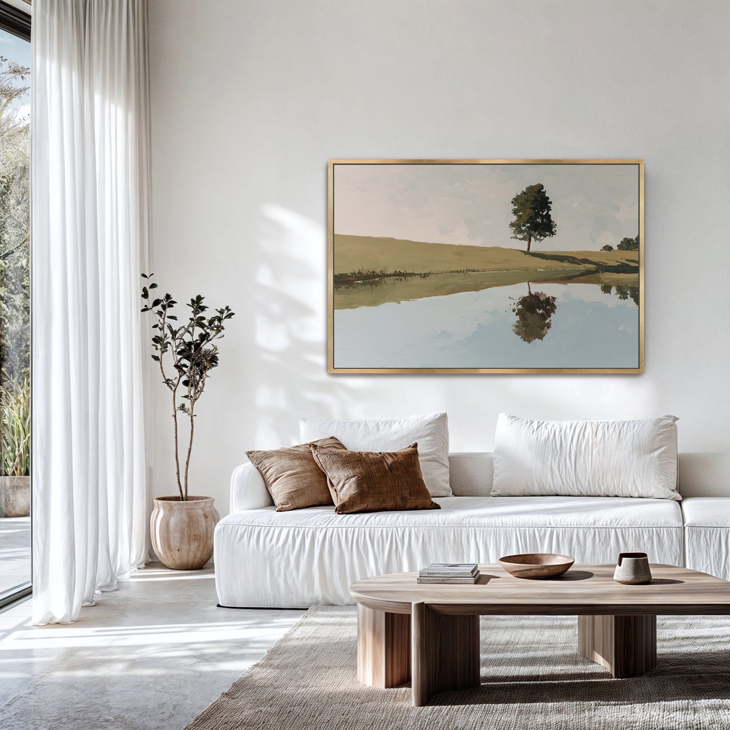 a serene living room with a white sofa, a wooden coffee table, and a large painting of a tree and a lake hanging on the wall.