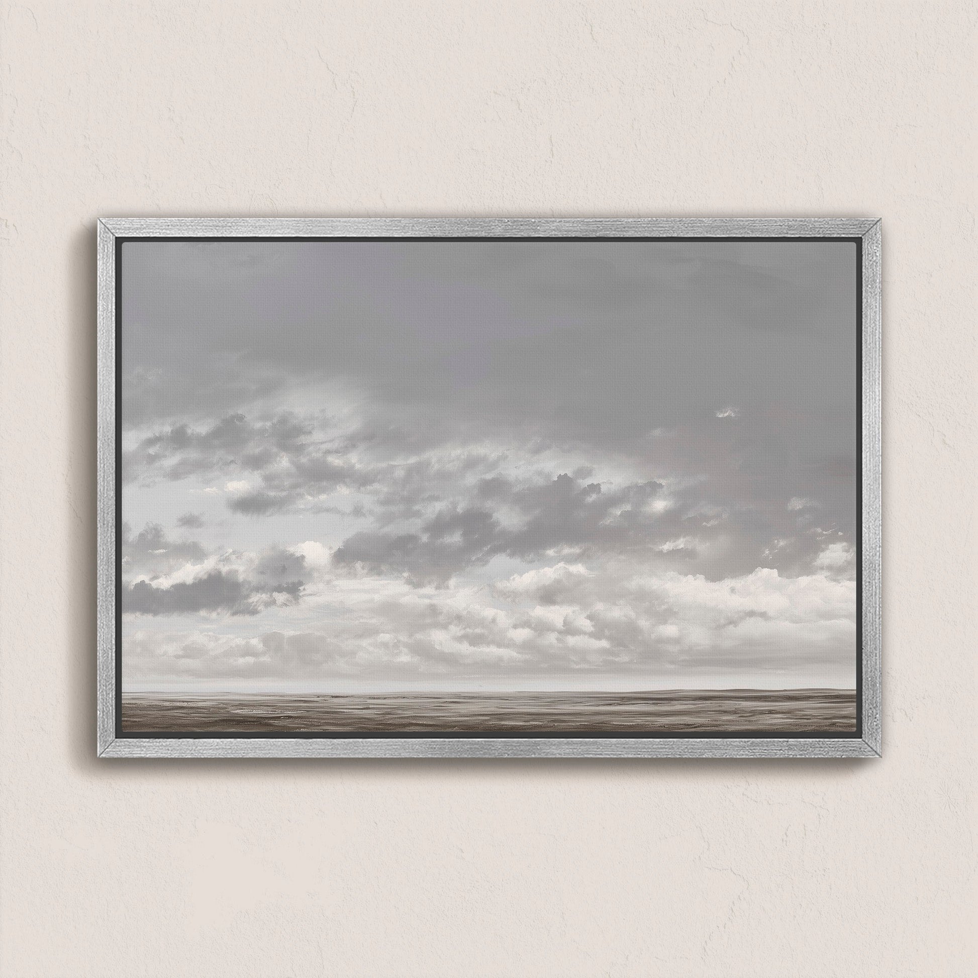 Duskfield canvas print of soft gray clouds over a tranquil plain in muted silvers and taupes, framed in silver-gray wood.