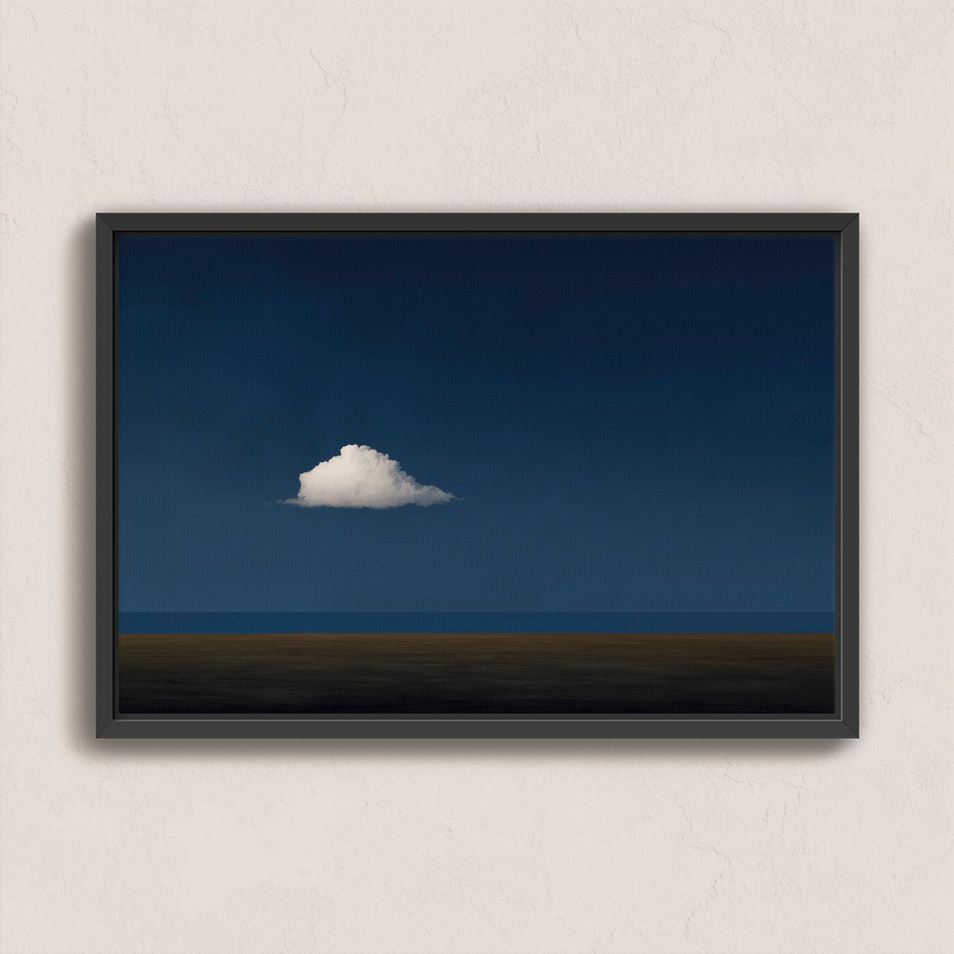 Nimbus Canvas Print featuring a solitary white cloud over a dark blue horizon, framed in black for modern and minimal interiors.