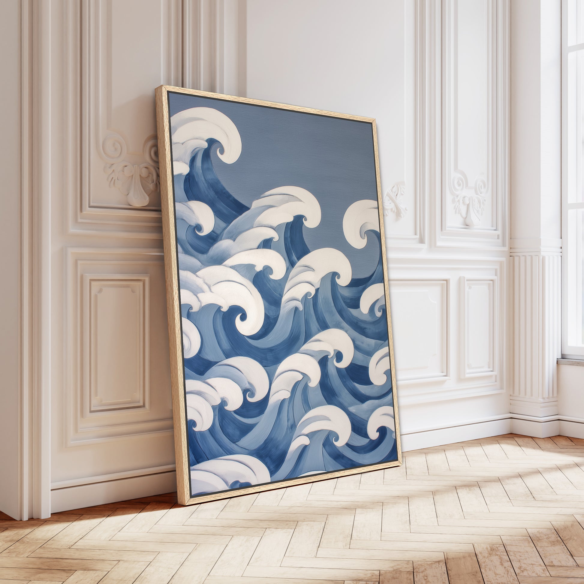A large framed artwork depicting a blue wave pattern is leaning against a white wall in a room with a wooden floor.