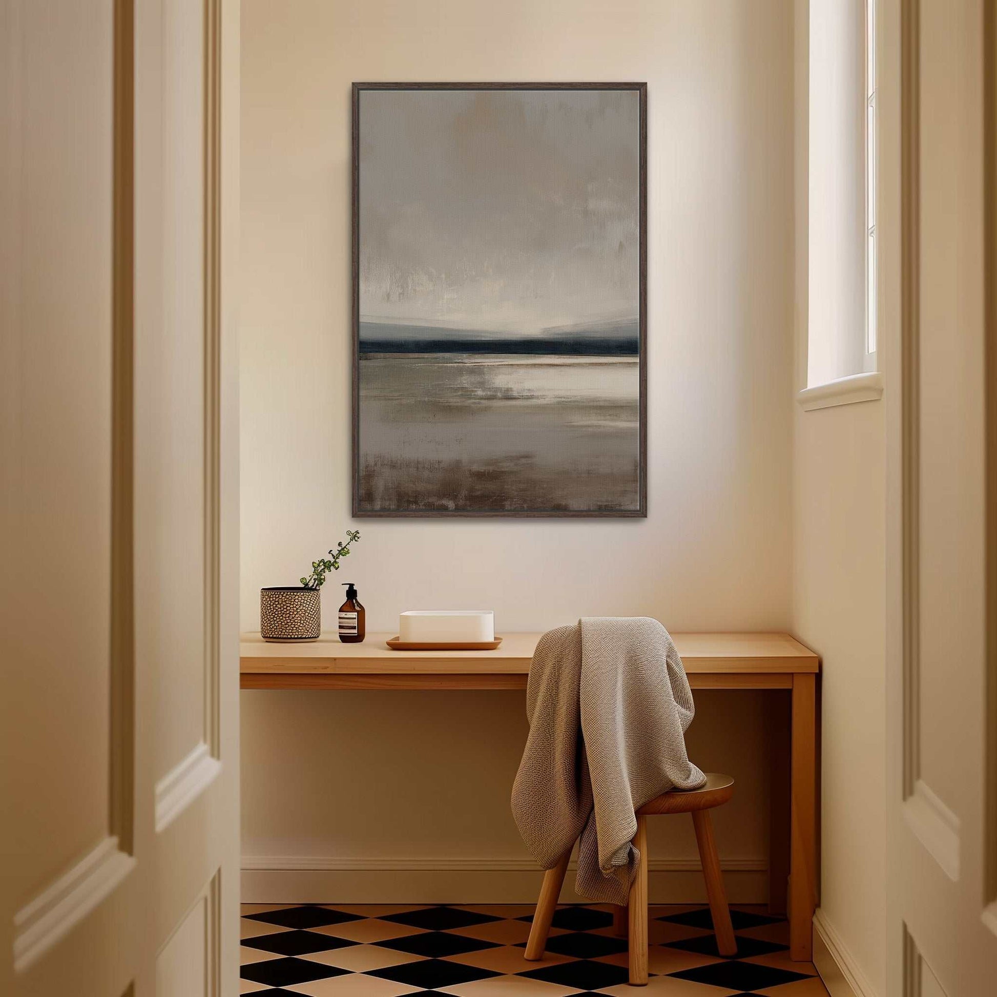 Vast canvas art with taupe, charcoal, and cream gradients in a tranquil landscape, framed and hanging above a wooden desk in a warm modern room