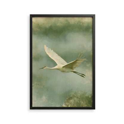A white crane with outstretched wings is captured in flight against a backdrop of green and gray hues.