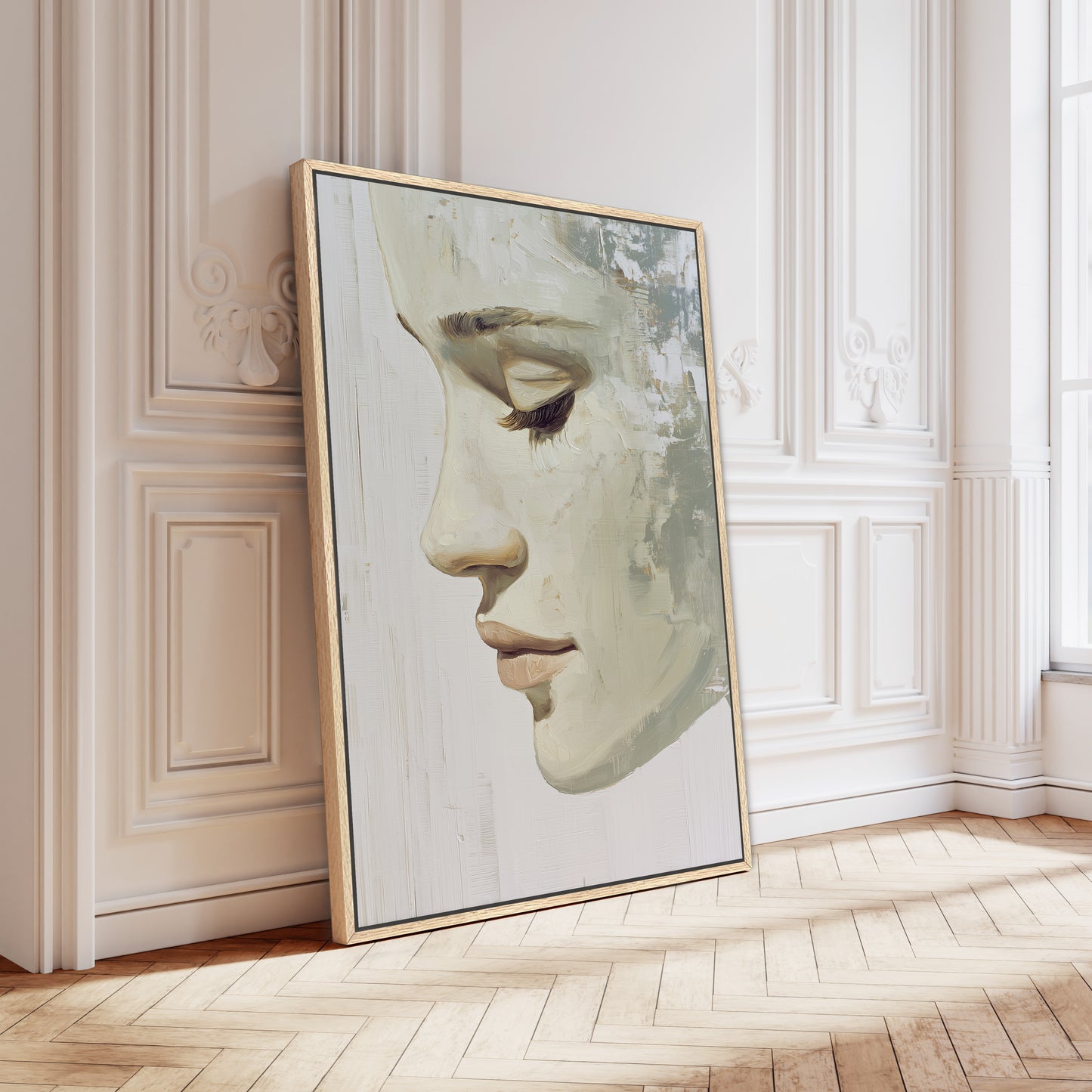 a large framed painting of a woman's face leaning against a white wall.