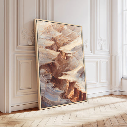 a large, framed painting of a rocky landscape with a striking color palette of brown, orange, and beige. The painting is leaning against a white wall, and the wooden floor beneath it adds a warm, natural element to the scene.
